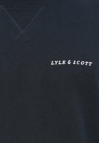Sötétkék pulóver lekerekített nyakkal, a bal mellen fehér hímezett "LYLE & SCOTT" felirattal. Puha szövettextúra.