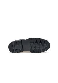 Sole in gomma nera con un design testurizzato, caratterizzata da scanalature profonde e modelli per una buona aderenza, tacco arrotondato e profilo piatto.