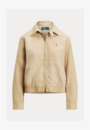 Smėlio spalvos lengva striukė su užtrauktuku priekyje, apykakle, tampriais rankogaliais ir apačia, ant kairiojo krūtinės pusės yra maža siuvinėta emblemėlė.