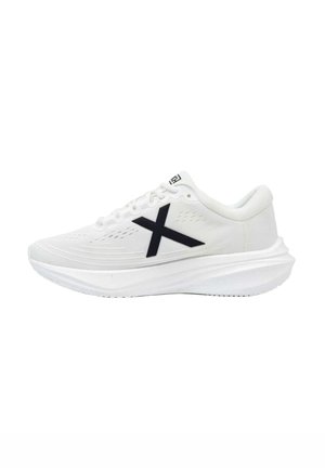 Zapatilla deportiva blanca con suela gruesa y logo negro "X" en el lateral, con cordones blancos y parte superior de malla transpirable.