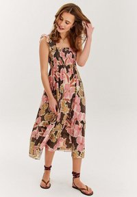 Kvetinové midi šaty so smockovanou vrchnou časťou, s volánovými ramienkami, v pastelových farbách ružovej, zelenej a hnedej, s vrstveným a plynulým dizajnom.
