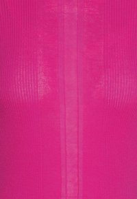 Haut ajusté côtelé en rose vif avec des sections semi-transparentes et des lignes verticales. Texture douce avec une légère brillance et une silhouette structurée.