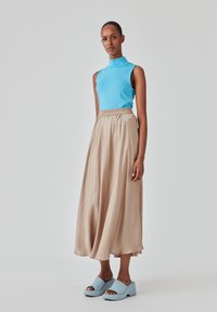 Lys blå ærmeløs top, beige flydende midi-skinner med elastisk talje og lys blå platform sandaler. Glat stof og afslappet pasform.