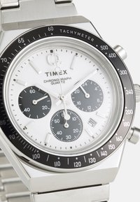 Silberner Edelstahlarmbanduhr mit einem weißen Zifferblatt, schwarzen Hilfszifferblättern, Tachymeterskalierung und einem Metallarmband. Verfügt über drei Chronographen-Hilfszifferblätter.