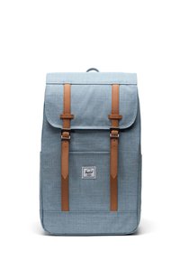 Light blue fabric backpack with brown leather straps and accents, featuring a flap closure and a front label logo. Classic rectangular shape.