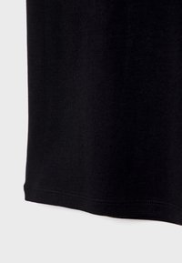 Černé bavlněné tričko s hladkou texturou, krátkými rukávy a rovného lemování se švy.