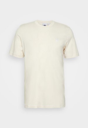 Helle beige Baumwoll-T-Shirt mit Rundhalsausschnitt, kurzen Ärmeln und einem kleinen weißen Logo auf der Brust. Glatte Textur und minimalistisches Design.