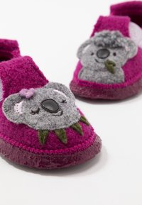 Rosa och grå tofflor för småbarn med en koala-design, mjukt filtmaterial, texturerad ovandel och gummisula med gröna bladdetaljer.