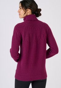 Jersey de punto con cuello alto en color fucsia, con detalles de punto texturizado en los hombros y un ajuste holgado. Tejido suave y esponjoso.