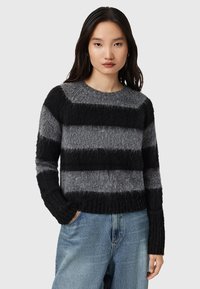 Maglione a righe in grigio e nero, realizzato in materiale morbido e con texture, con scollatura rotonda e polsini a coste, caratterizzato da un design corto.