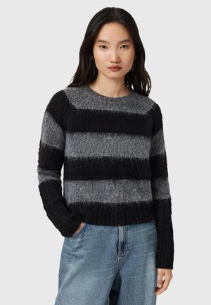 Pull rayé gris et noir, en matériau doux et texturé, avec un col rond et des poignets côtelés, présentant un design court.