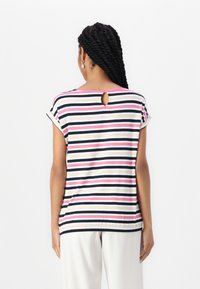 Stripet kortermet topp i marineblå, rosa og beige. Har en rund halslinje med en nøkkelhullkutt bak og en avslappet passform.
