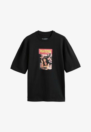 Schwarzes übergroßes T-Shirt mit einer Grafik einer liegenden Frau, die raucht, darüber der Text "PULP FICTION" in Gelb auf rotem Hintergrund.
