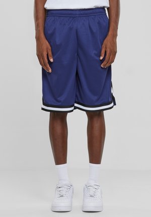 Navy basketball shorts yang terbuat dari mesh yang bernapas, menampilkan hem bergaris hitam dan putih serta detail celah samping untuk kemudahan bergerak.