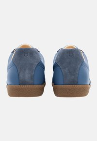 Baskets en cuir bleu avec des accents en daim sur le talon, semelle en caoutchouc gomme, forme arrondie et design minimaliste. Présente des détails cousus sur la semelle.