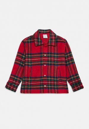 Veste rouge à carreaux boutonnée, avec un col, des manches longues et deux poches à l’avant, présentée sur un fond uni.