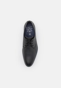 Chaussure habillée noire en cuir texturé avec un laçage, présentant un motif en diamant et un accent bleu autour de la semelle. Taille 42. Marque : Bugatti.