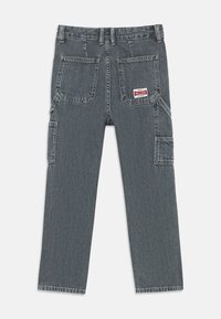 Hallid denim püksid sirge sääre disainiga, millel on neli taskut, seljal väike silt ja kergelt pleekinud tekstuur.