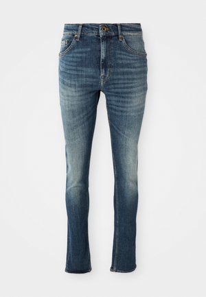 Dongeribukser i mørkeblå med lys fading, rett ben design, fem lommer og kontraststing. Messing knapp og glidelås lukking.