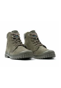 Bottes chelsea vert olive en suède, avec une semelle en caoutchouc texturée, des lacets et une bordure en fausse fourrure au col.
