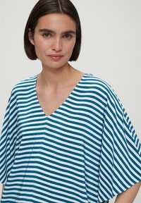 Gestreepte V-hals shirt in blauw en wit, met een losse pasvorm en brede mouwen. Zachte stof met een gladde textuur.
