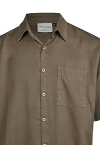 Kurzarmhemd aus olivfarbener Bio-Baumwolle, mit einem Knopfverschluss vorne, einer Brusttasche und einem lockeren Schnitt.