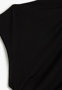 Sort stof med en glat tekstur, der har et draperet, løst design og brede ærmeåbninger, skåret til en afslappet pasform.