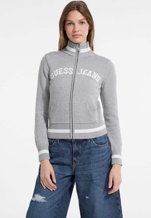 Gray knit zip-up sweater with "GUESS JEANS" text, ribbed collar and hem, two front pockets, and white stripe accents at cuffs and hem.