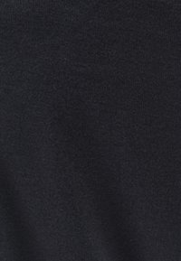 Ciemnoniebieska dzianina o delikatnej fakturze, z subtelnymi różnicami w odcieniu i gładką, miękką powierzchnią.