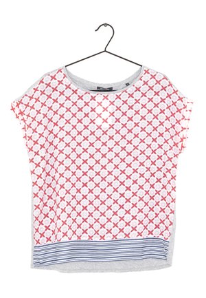 Blusa blanca de manga corta con estampado floral rojo y bajo a rayas azules colgada en una percha de alambre negro.