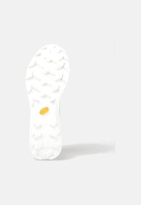 Bílá podrážka s hlubokými vzory a žlutým gumovým logem. Tvar je na špičce zakřivený, navržený pro lepší přilnavost na různých površích.