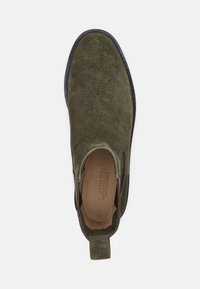 Green suede slip-on shoe with a rounded toe, elastic side panels, and a textured outsole, featuring a back pull tab for easy wear.