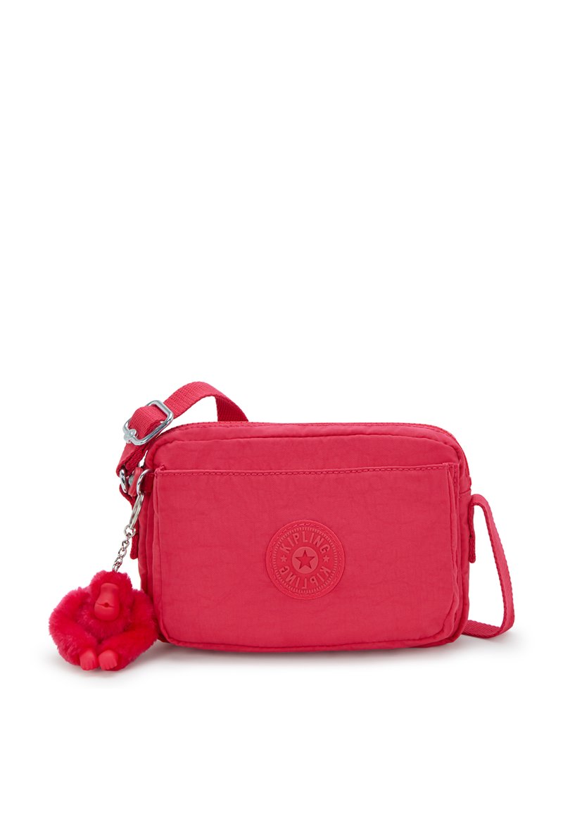 Kompakt rosa nylon crossbody-väska med en texturerad yta, som har en logopatch framtill och en röd fluffig apa nyckelringaccessoar.