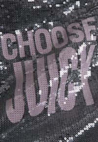 Fekete flitteres anyag, melyen nagy, rózsaszín betűkkel olvasható a "CHOOSE JUICY" felirat. Fényes textúrájú, tükröződő felületekkel.