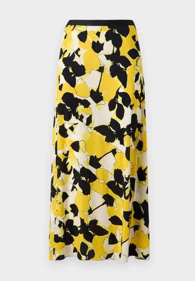 Geltona gėlių sijonas su juodais ir baltais lapų raštais, plaukiantis audinys ir prigludusi juoda liemens juosta. A-formos siluetas.