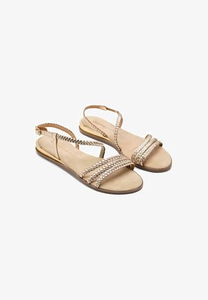 Sandalias de cuero marrón con tiras trenzadas y una suela plana. Presentan una plantilla texturizada y acentos metálicos en el talón.