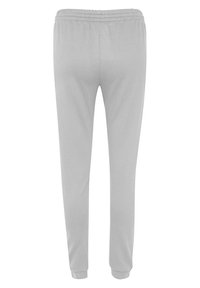 Lichtgrijze sweatpants gemaakt van zachte stof, met een elastische tailleband en taps toelopende boorden bij de enkels. Gladde textuur, zonder patronen.