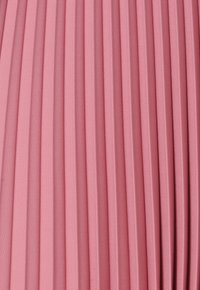 Falda plisada en tela de un suave color rosa. Presenta pliegues verticales, textura suave y color uniforme sin patrones ni elementos adicionales.