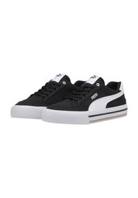 Sneakers neri in tela con una striscia laterale bianca, suola bianca, lacci neri e un'etichetta sulla linguetta bianca con il logo Puma.