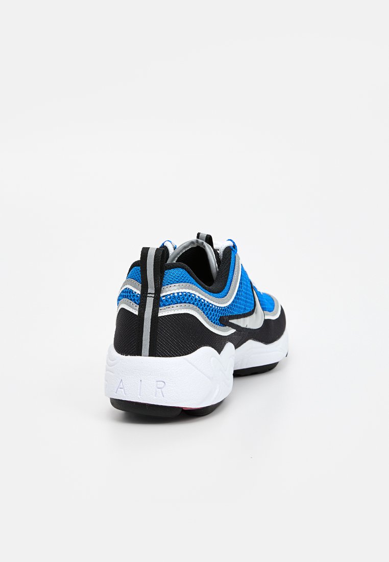 Zapatilla deportiva negra y azul con parte superior de malla, cuello acolchado y suela texturizada. Cuenta con una entresuela blanca con la palabra 'AIR' en relieve en el talón.