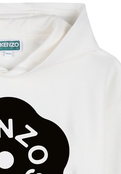 Biała bluza z kapturem z dużym czarnym okrągłym wzorem i zniekształconym białym napisem, z metką Kenzo Kids wewnątrz kołnierza.