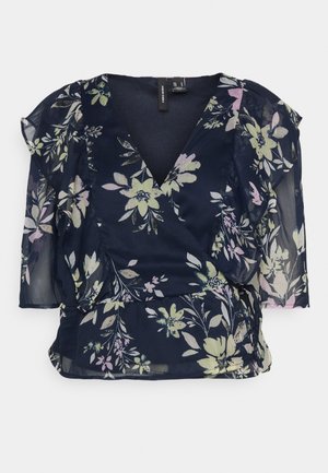 Blusa floral azul-marinho com mangas 3/4 transparentes, decote em V e detalhes em babados. Apresenta padrões de flores em verde claro e rosa.