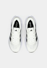 Witte sportieve schoenen met zwarte accenten en een ontwerp met drie strepen, voorzien van een gemêleerde mesh bovenzijde, platte veters en een gevoerde zool.