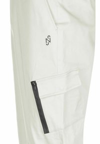 Weiße Cargo-Hosen aus leichtem Material, mit einer seitlichen Tasche und einem schwarzen Reißverschluss sowie einem kleinen schwarzen Logo, das sich in der Nähe der Tasche befindet.