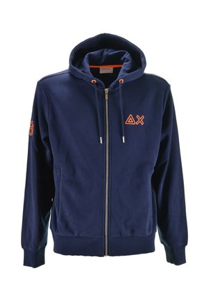 Felpa con zip di colore blu navy, dotata di cappuccio, tasche frontali, punte del cordino arancioni e simboli Delta e X ricamati in arancione sul petto e sulla manica.