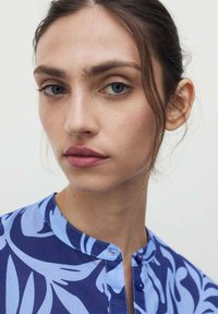 Blauw bloemenpatroon shirt met een mandarin kraag, voorzien van een knoopsluiting, gemaakt van lichtgewicht stof met een gladde textuur.