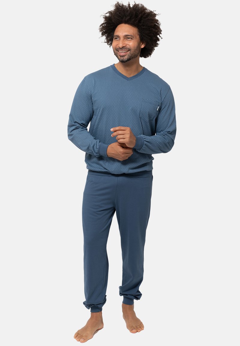 Sininen oleskelusetti, joka koostuu kuvioidusta pitkähihaisesta paidasta ja yksivärisistä joustavista housuista, joissa on kapenevat lahkeet, valmistettu pehmeästä ja mukavasta kankaasta.