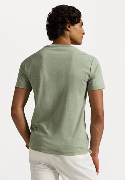 Τιράντα πράσινη μπλούζα σε μαλακό μείγμα βαμβακιού, με στρογγυλή λαιμόκοψη και άνετη εφαρμογή. Λείος ιστός με διακριτική ραφή.