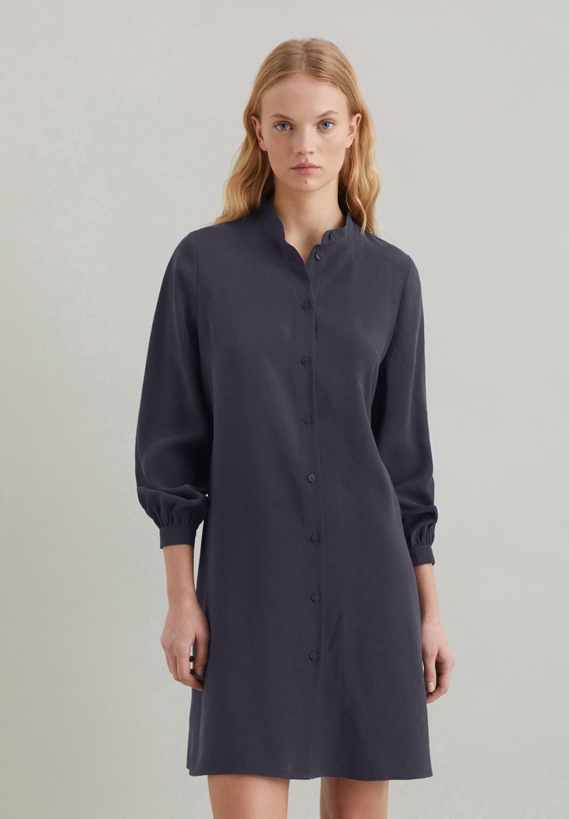 Abito button-up blu scuro con colletto alla cinese, maniche lunghe a sbuffo e silhouette dritta, realizzato in tessuto liscio.