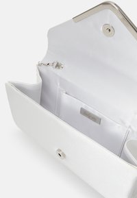 Biała kopertówka z satyny o eleganckim, uporządkowanym designie. Posiada srebrne zatrzaski, wewnętrzną kieszeń oraz ozdobę z logo.